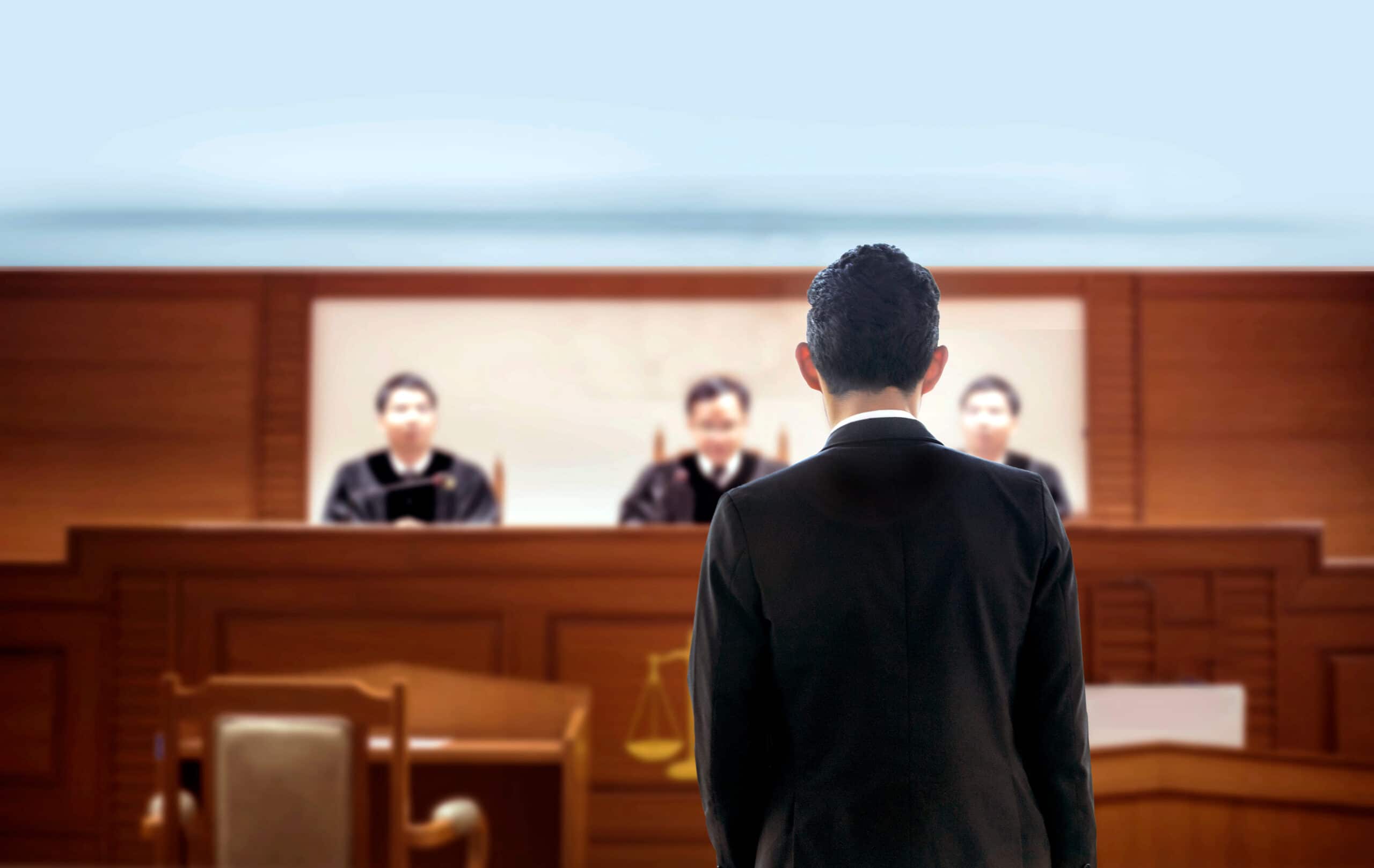 A man in black suit standing in front of judges.